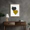 Framed artwork of Love Forever digital wall art with two hearts in black and gold on a grey wall above a wooden console table.